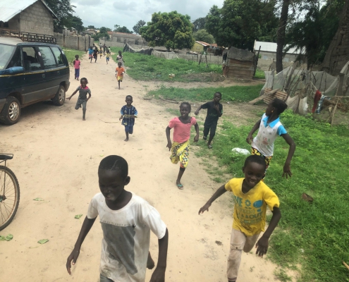 2019 Senegal: Kinderen rennen naar school voor een schrift